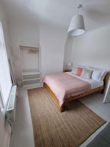 a bedroom with a bed with a rug and a lamp at Cosy modern house in Liverpool