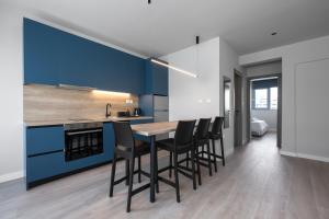 a kitchen with blue cabinets and a table and chairs at #Luxlikehome Lux Locals 1 in Thessaloniki