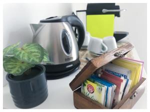 a kitchen counter with a toaster and a plant and books at Lingotto Side House - Affitti Brevi in Turin