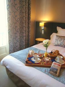A bed or beds in a room at Logis hôtel restaurant Le Goyen