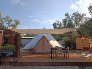 een tent op een houten terras met een tafel en stoelen bij Meltheane in Lygia +26 foto's