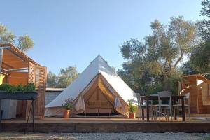 een tent op een terras met een tafel en stoelen bij Meltheane in Lygia
