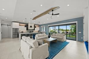 a living room with white furniture and a kitchen at The Ringling Estate in Sarasota