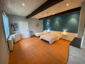 1 dormitorio con 2 camas y suelo de baldosa de color naranja en Maison d'Hôtes - L'Hôthentique, en Gaillan-en-Médoc