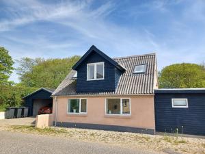 een huis met een blauw dak bij Tæbring Holiday Home in Nykøbing Mors
