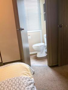 a bathroom with a toilet and a bed in a room at Aurvegene in Weeton