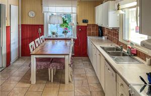 a kitchen with a wooden table and a sink at 3 Bedroom Lovely Home In Frnsta in Fränsta