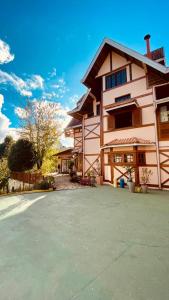 una casa grande con una entrada delante de ella en Village de France Araucárias, en Campos do Jordão