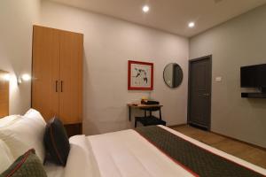 a hotel room with a bed and a television at Townhouse Royapettah Near U.S Consulate in Chennai