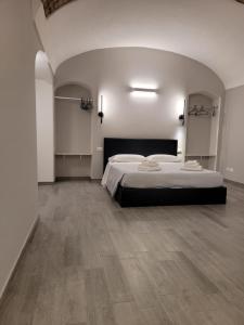 sypialnia z dużym łóżkiem i drewnianą podłogą w obiekcie Relais Virginia Home w San Remo