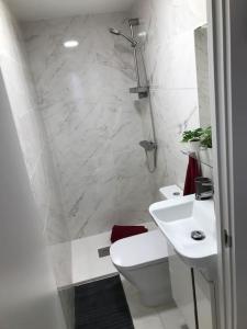 y baño con aseo, lavabo y ducha. en Precioso Apartamento nuevo con Jardín privado, en Paracuellos de Jarama