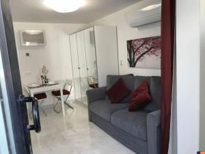 ein Wohnzimmer mit einem Sofa und einem Tisch in der Unterkunft Precioso Apartamento nuevo con Jardín privado in Paracuellos de Jarama