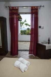 una camera da letto con due asciugamani su un letto con finestra di Il Gelso Vacanze a Malfa