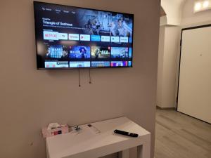 TV a schermo piatto appesa a un muro con tavolo di Relais Virginia Home a Sanremo