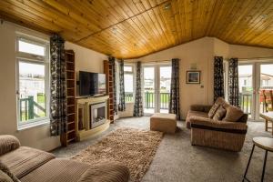 sala de estar con 2 sofás y TV en Modern 4 Berth Lodge With Decking At Manor Park In Hunstanton Ref 23024w, en Hunstanton