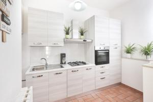 a kitchen with white cabinets and a sink at Green Coast House 4 in Piombino