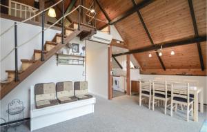a dining room with a table and chairs and wooden ceilings at Three-Bedroom Holiday Home In Romo in Mølby