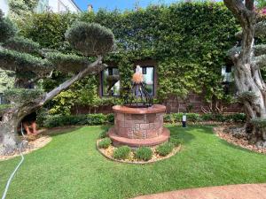 einen Garten mit einem Brunnen inmitten eines Gartens in der Unterkunft Nisi Hotel in Ayvalık