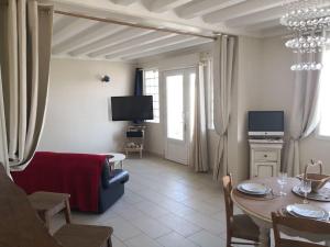 a living room with a table and a couch at Spa privatif face mer Riva Romantic & SPA in Ouistreham