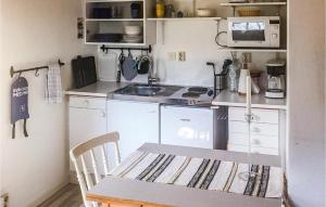 een kleine keuken met een tafel en een magnetron bij 2 Bedroom Cozy Home In Vstervik in Västervik