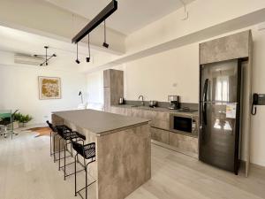 uma grande cozinha com um balcão e um frigorífico em Premium apartament Distrito Quartier 1 br Retiro em Buenos Aires