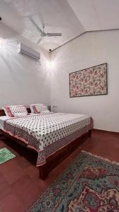 a bedroom with a bed in a room with a rug at The Room by Sarwaa in Varkala