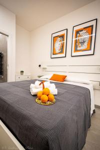 a bedroom with a bed with a plate of oranges on it at Sikelia Apartments in Pozzallo
