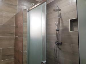 y baño con ducha y puerta de cristal. en Chinyonga Guesthouse, en Limbe