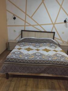 uma cama com uma colcha num quarto em Vacation home on Rybzavodskaya em Lidzava