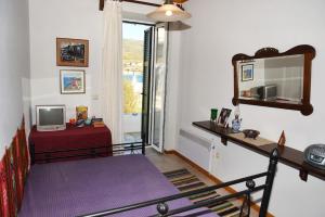 a living room with a bed and a mirror at Panos House Andros in Andros