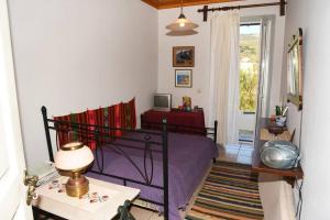 a bedroom with a bed and a table with a lamp at Panos House Andros in Andros