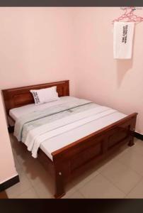 1 cama en un dormitorio con marco de madera en MUSITA GUEST WING MOTEL, 