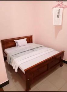 a bed in a room with a wooden bed frame at MUSITA GUEST WING MOTEL 