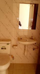 y baño con aseo, lavabo y espejo. en MUSITA GUEST WING MOTEL, 