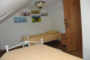 a bedroom with two beds and pictures on the wall at Ty-Hapus cottage in Jordanston