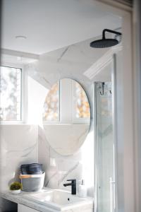 Baño blanco con lavabo y espejo en NEW Luxury 3BR Apartment in Old Town, Free Parking en Haapsalu
