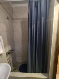 uma casa de banho com um chuveiro com uma cortina de chuveiro azul em Vacation home on Rybzavodskaya em Lidzava