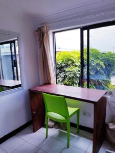 a desk with a green chair in front of a window at Chinyonga Guesthouse in Limbe