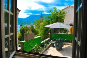 a view from a window of a patio with an umbrella at Apartment Mediterraneo Seagull in Perast