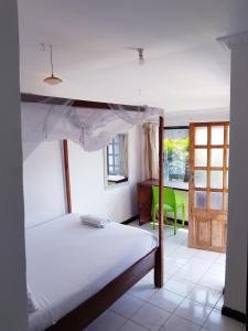 a bedroom with a bed and a green chair at Chinyonga Guesthouse in Limbe