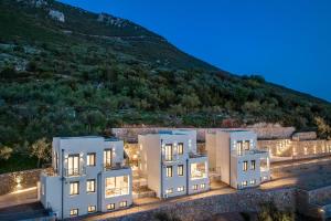 een weergave van drie witte gebouwen voor een berg bij Kalma Luxury Villas in Kalamata