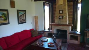 a living room with a red couch and a fireplace at chale da montanha in Taubaté