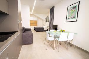 a living room with a table and white chairs at Sikelia Apartments in Pozzallo
