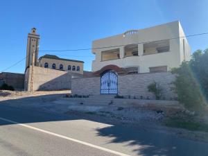 a building with a gate and a clock tower at Villa Ihaddadene in Nador