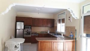 cocina con armarios de madera y encimera en Villa Ihaddadene en Nador