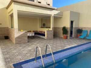 a house with a swimming pool next to a building at Villa Ihaddadene in Nador
