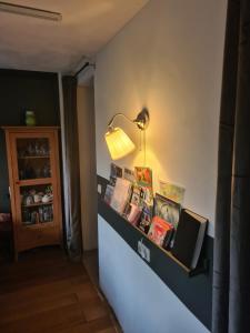 ein Zimmer mit einem Regal mit Büchern und einer Lampe in der Unterkunft Bed & Breakfast 28 appartement met ruime tuin en gratis prive parkeren ideaal voor gezinnen in Assen