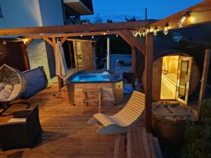 a deck with a hot tub and a table and chairs at Apartament na wzgórzu in Muszyna