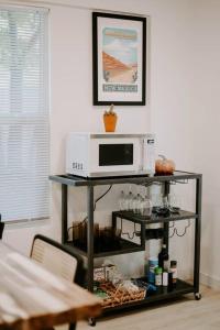 a microwave on top of a shelf in a kitchen at Saguaro at Cactus Flower-HOT TUB-Pet Friendly-No Pet Fees! in Albuquerque