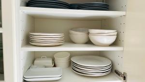 a cupboard filled with plates and bowls and dishes at Pod Świerkami in Boszkowo